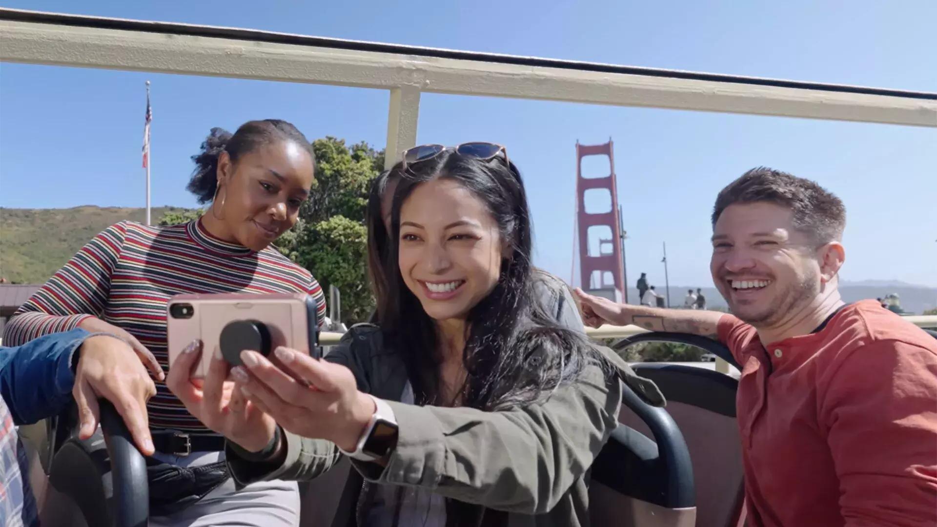 Un gruppo di visitatori si fa un selfie durante un tour in autobus vicino al Golden Gate Bridge. San Francisco, California.