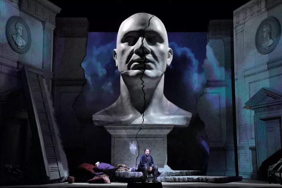 Un gigantesco busto di un uomo incombe su due attori sul palco di una produzione di Don Giovanni a San Francisco.