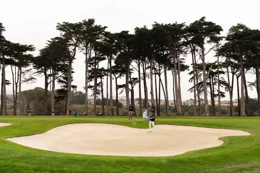 在贝博体彩app哈定高尔夫球场的沙坑里打高尔夫球的人, California.