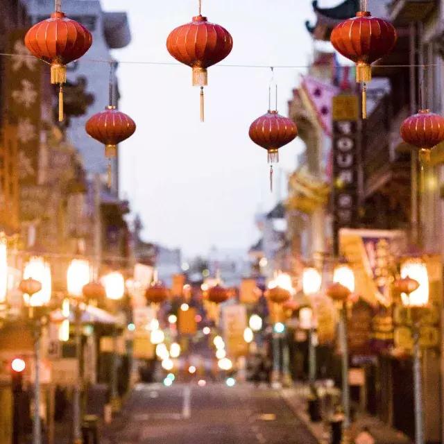 Vista de perto de uma série de lanternas vermelhas penduradas acima de uma rua em 唐人街. 加州贝博体彩app.