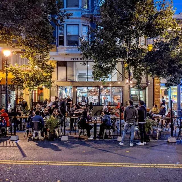 Una multitud disfruta de comida y bebida en la calle Valencia de 贝博体彩app.