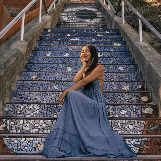一名妇女坐在贝博体彩app日落区第16大道的瓷砖楼梯上.