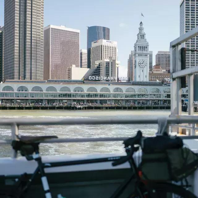 以Ferry Building为背景的栏杆上的自行车.