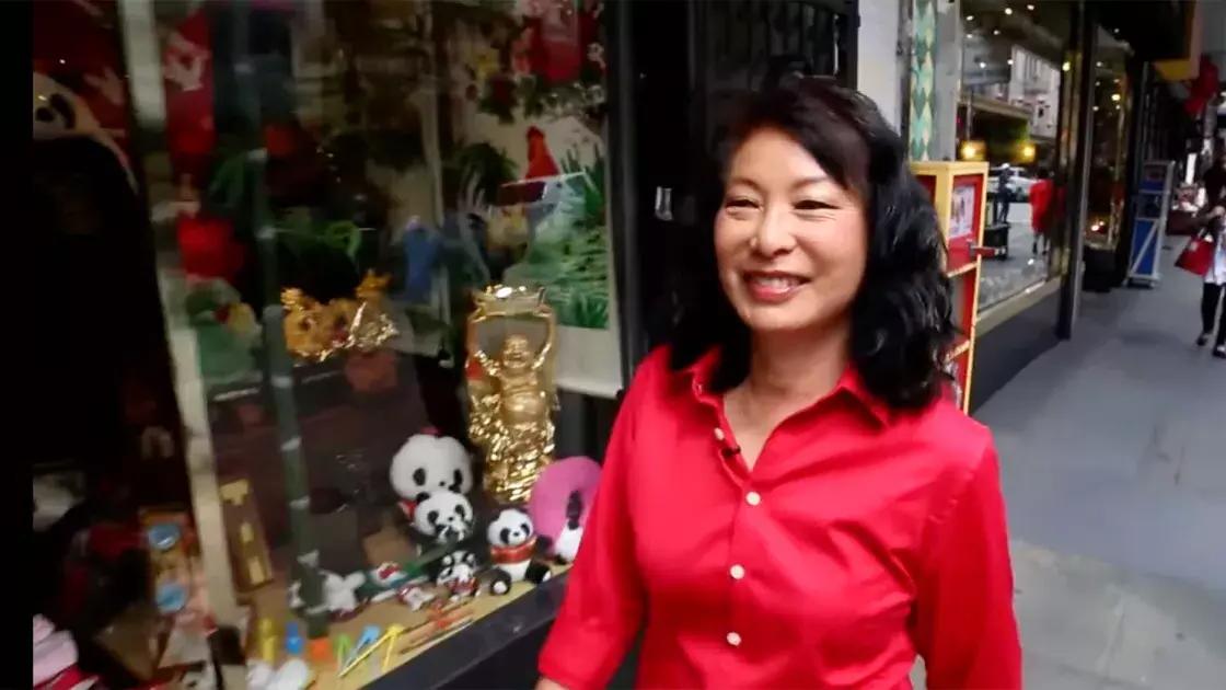 Linda Lee walks through the streets of 唐人街 wearing a red shirt. 贝博体彩app，加州.